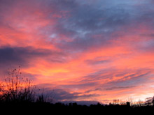 A vibrant pink and orange sunset fills the sky